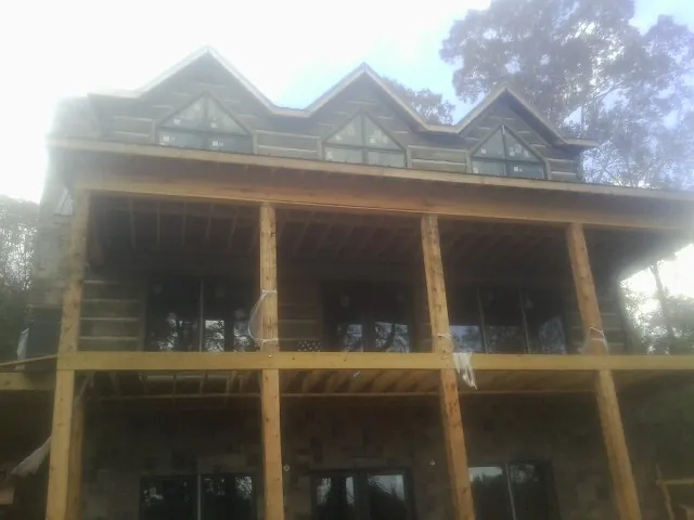 Dormers and porch framing on a large log home under construction — Roof Coating work by our crew in Antelope