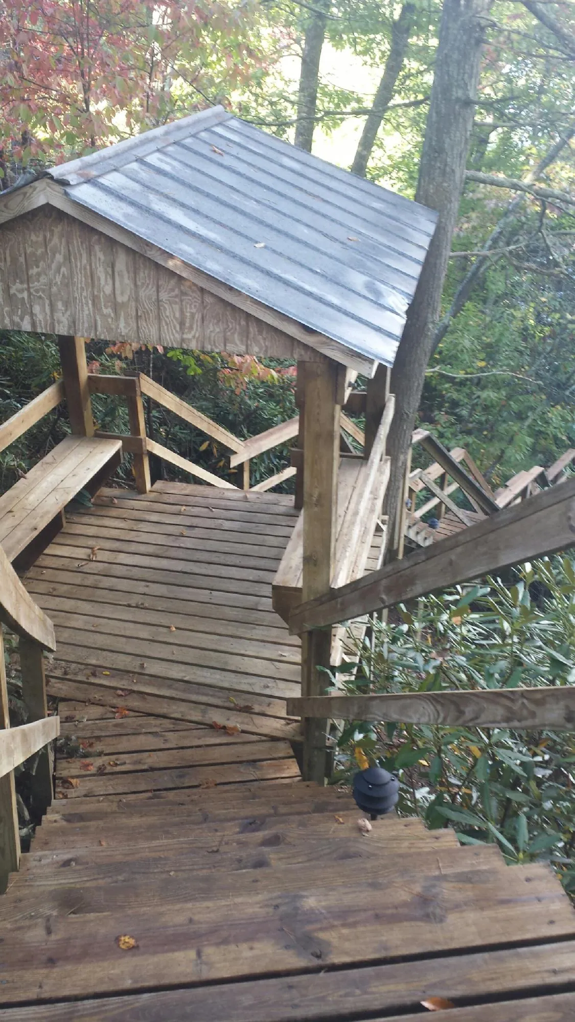 Metal roofed shelter over wooden steps on a wooded walkway — Skylight Repair & Installation work by our crew in Antelope